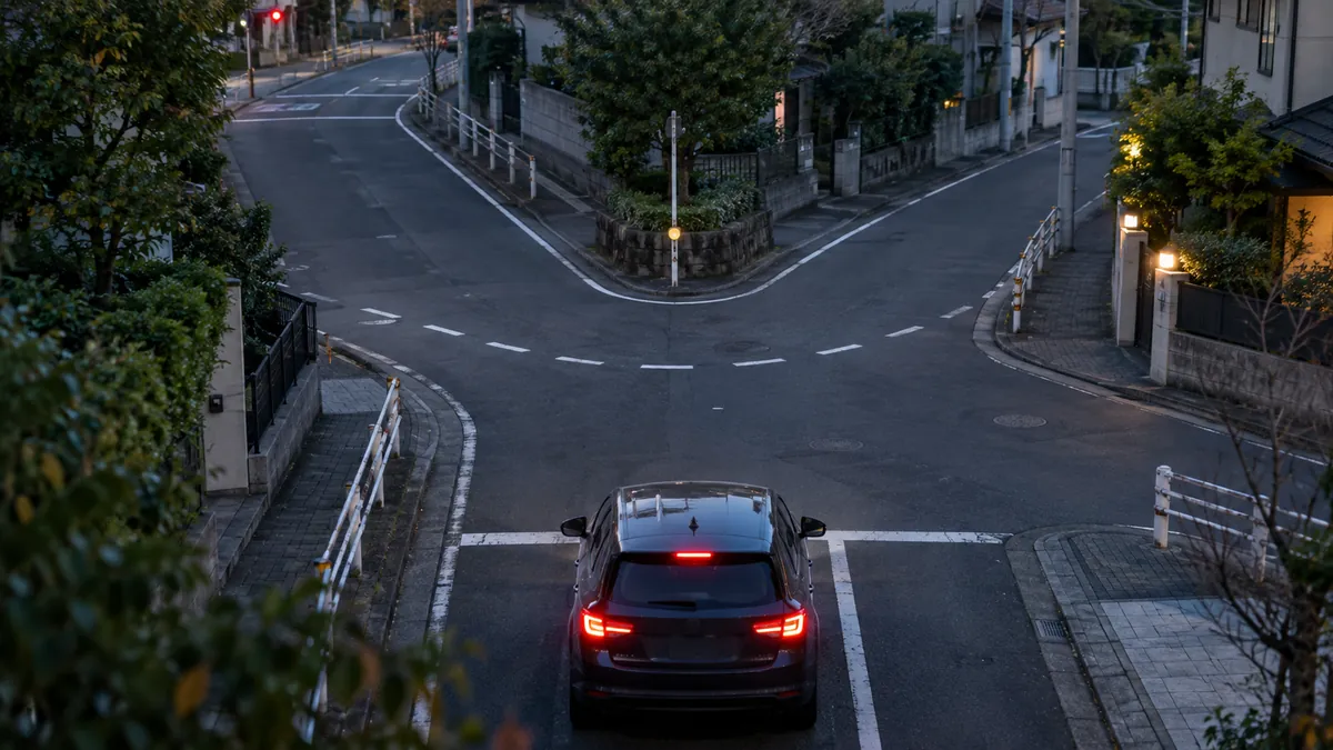 分かれ道の交差点で信号待ちをする1台の車